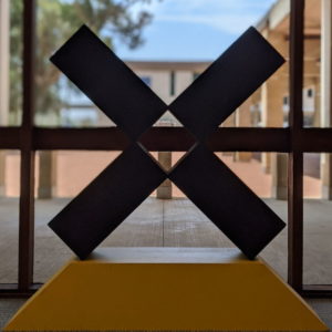 sculpture shaped as a large black x on a yellow base from the Fad x exhibition
