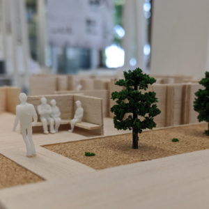 Miniature model of people in an outdoor structure, titled Temporary Theatre and Artisanal Marketplace, by Sebastian Smith