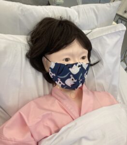 Image of a mannequin dressed as a patient in a hospital bed