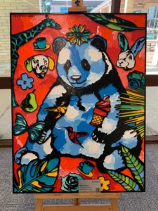 Large woodcut painting featuring a panda