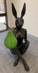 Bronze hare statue holding a green pear