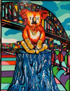 Colour woodcut artwork featuring a koala and the Sydney Harbour bridge